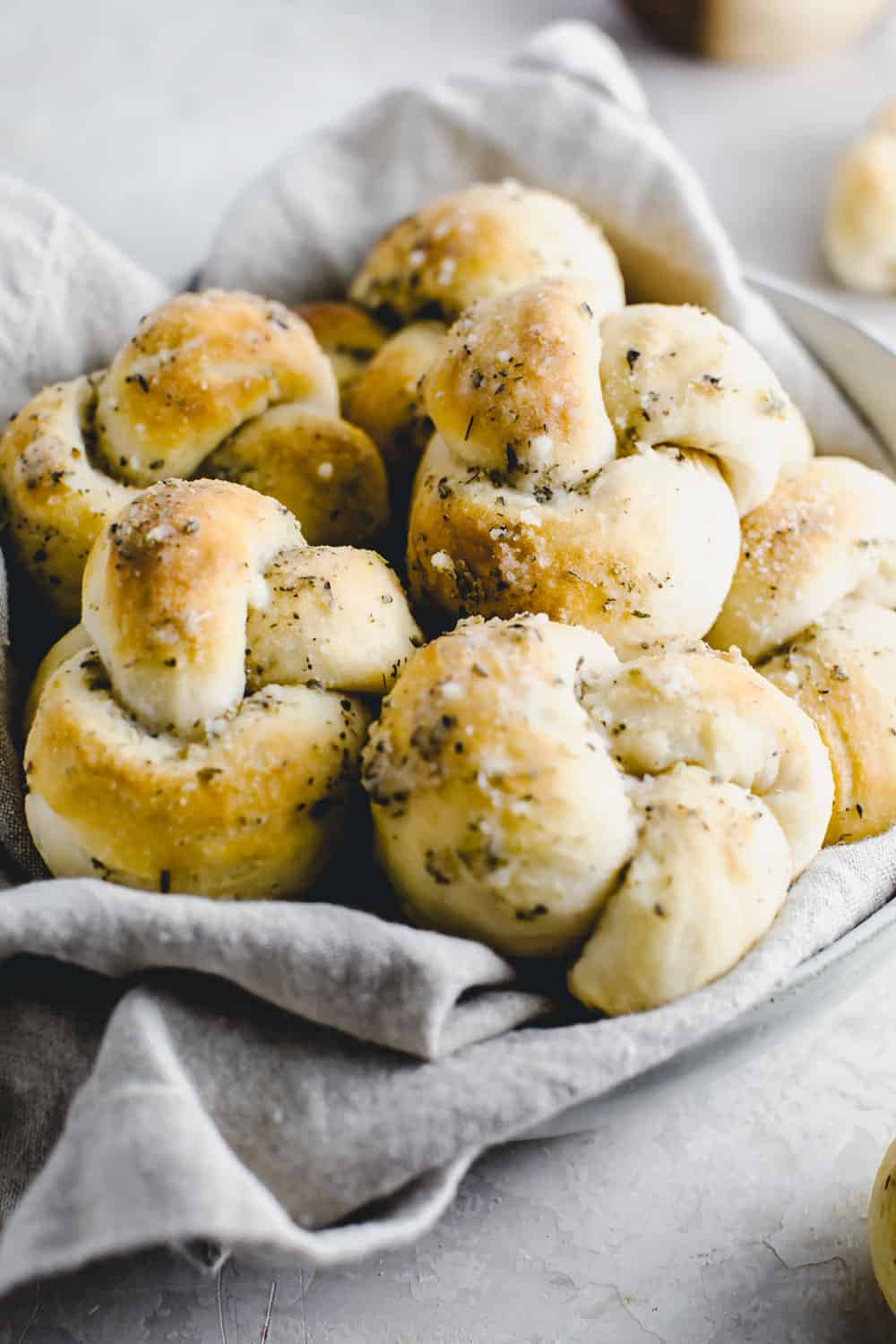 Easy Parmesan Knots are quickย and simple warm, buttery garlic knots that twist to perfection in 20 minutes! These won't last long at the dinner table!ย Parmesan knots in a basket