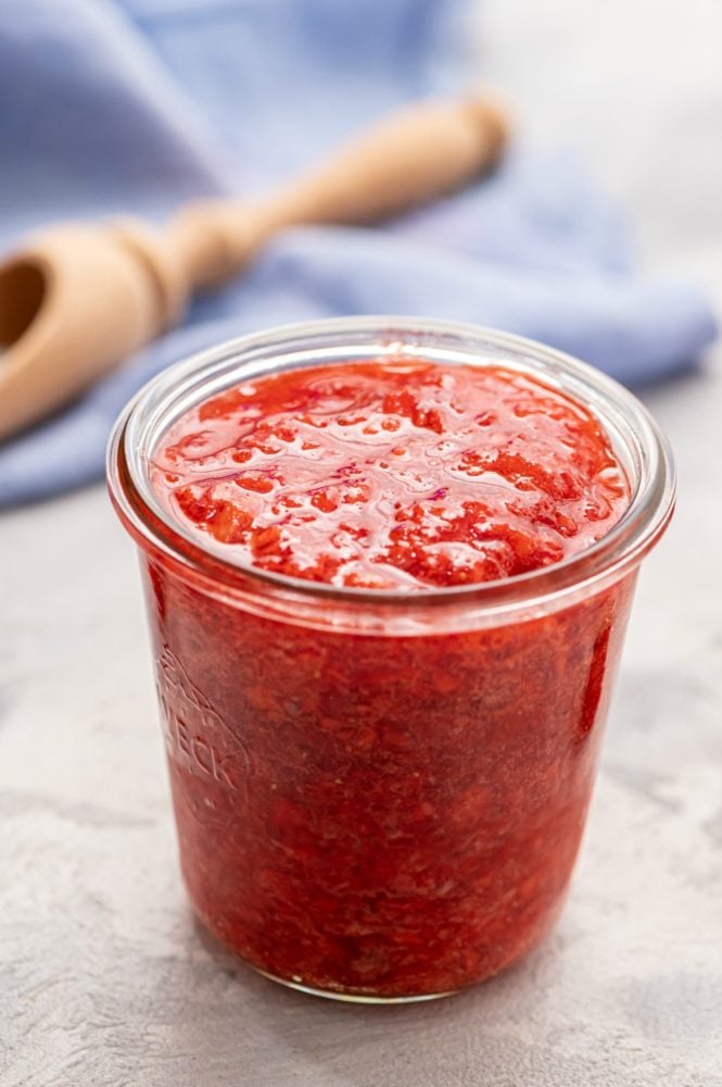 Homemade Strawberry Freezer Jam is a sweet and chunky jam that you can make quickly and enjoy for up to a year!ย Once you see how easy it is to make this strawberry jam, you will never buy it from a store again! Strawberry freezer jam in a glass jar.