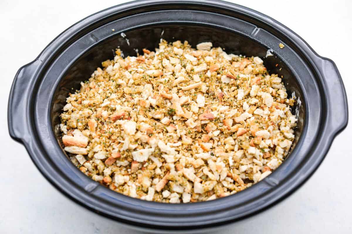 Toss your leftover ham in the slow cooker with potatoes, melty cheese, and buttery stuffing for my ridiculously easy Slow Cooker Ham and Potato Casserole! Crockpot with the ham, potato and soup mixture under the stuffing mixture.