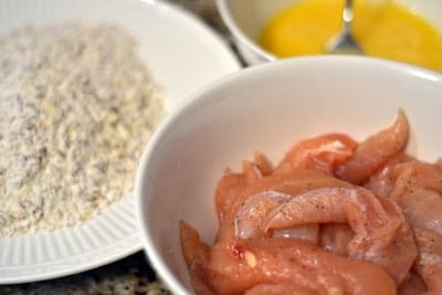 This is the perfect summer recipe. I loved it and I didn't feel guilty after eating it. I love fruit in my salads. But I have never tried peaches. Oh my it was good. And the dressing was delicious on top. This recipe has a little more to it, but it is a nice change! Un-cooked chicken in a white bowl with batter next to it on a white plate.