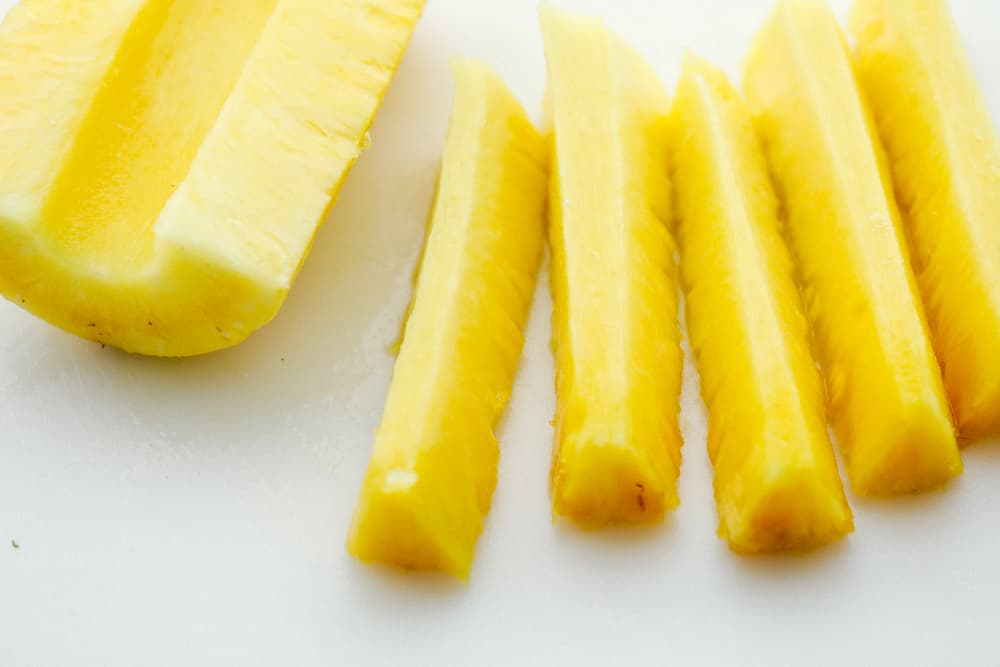 Pineapple spears that get coated in a buttery brown sugar cinnamon glaze and caramelize on the grill! Thisย will be one of the most amazing sides that you grill this summer! Pineapple cut into spears.