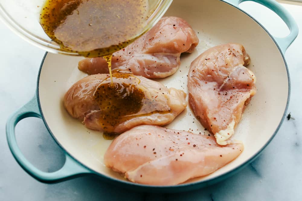 Honey Butter Baked Chicken is a rich and flavorful dinner that has tender baked chicken made with only four ingredients! The blend of honey and butter is the perfect combination for a flavorful chicken dinner.ย Chicken breasts in a pan being glazed with the whisked ingredients.