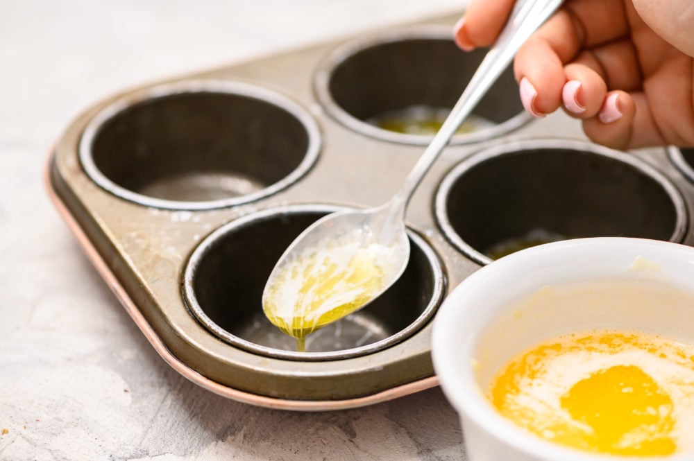 Mini Peach cobbler is the perfect warm, sweet dessert to satisfy any sweet tooth.ย The flaky crust and sweet fruit filling will have you liking the spoon! Especially when you top it with some creamy vanilla ice cream! Adding butter by the spoon into the muffin tins.