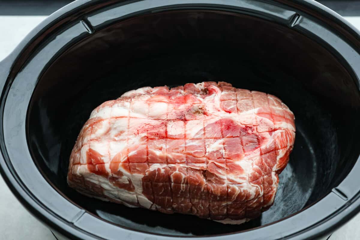 This is the BEST sweet pork taco recipe! It tastes just like Cafe Rio's famous sweet pork, with a blend of sweet and tangy flavors that melt into tender, juicy meat. It's perfect for tacos, salads, burritos, nachos, and anything else you can dream up! Overhead shot of pork roast in bottom of crock pot.
