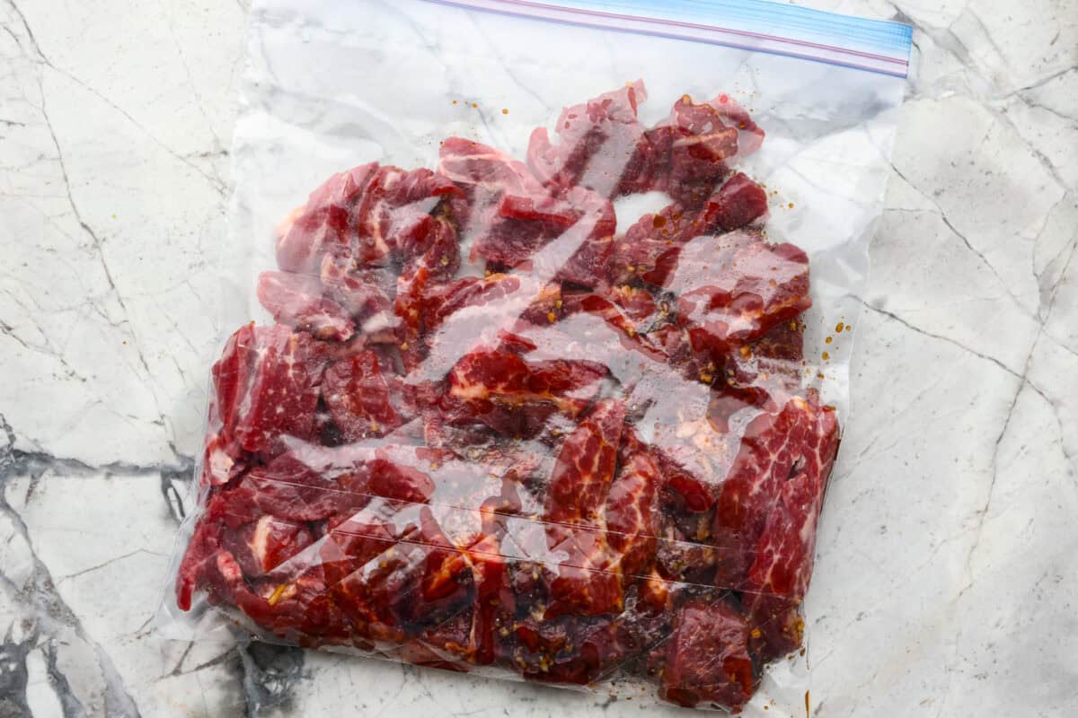 This Mongolian beef and broccoli recipe is the best P.F. Chang’s copycat recipe. You will love the combination of tender beef, vibrant broccoli and intensely flavorful sauce. Save yourself money while making your family happy with this quick and easy recipe. Overhead shot of flank steak in a ziploc bag with marinade.