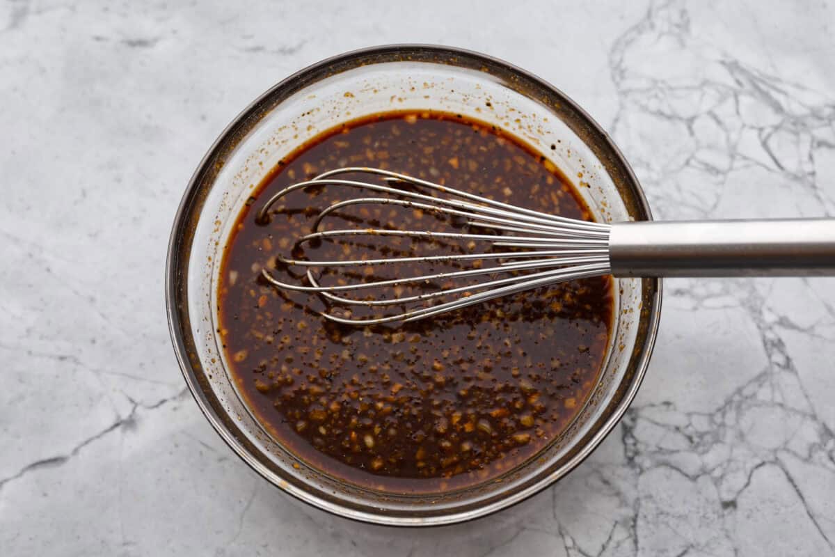 This Mongolian beef and broccoli recipe is the best P.F. Chang’s copycat recipe. You will love the combination of tender beef, vibrant broccoli and intensely flavorful sauce. Save yourself money while making your family happy with this quick and easy recipe. Overhead shot of sauce ingredients whisked together in a glass bowl.