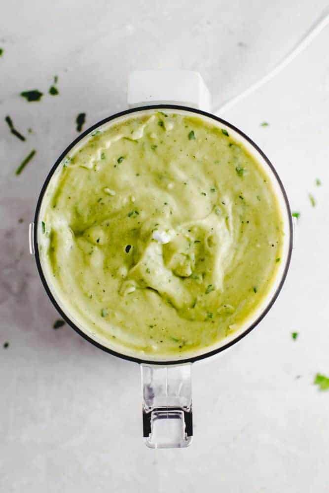 hicken Enchiladas with an Avocado Cream Sauceย is a delicious and easy weeknight meal that everyone will love. They are packed with flavor and drizzled with a sauce that dreams are made of. If you love avocados, this recipe is for you! Avocado cream sauce being blended together.