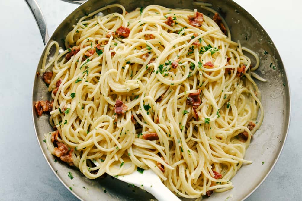 Creamy Bacon Carbonaraย is a classic Italian creamy pasta. Bacon, mushrooms, and onions are cooked together and tossed in aย cheesy, rich egg yolk sauce for an easy 30 minute meal! A quick and easy dinner that is made in minutes! creamy bacon carbonara