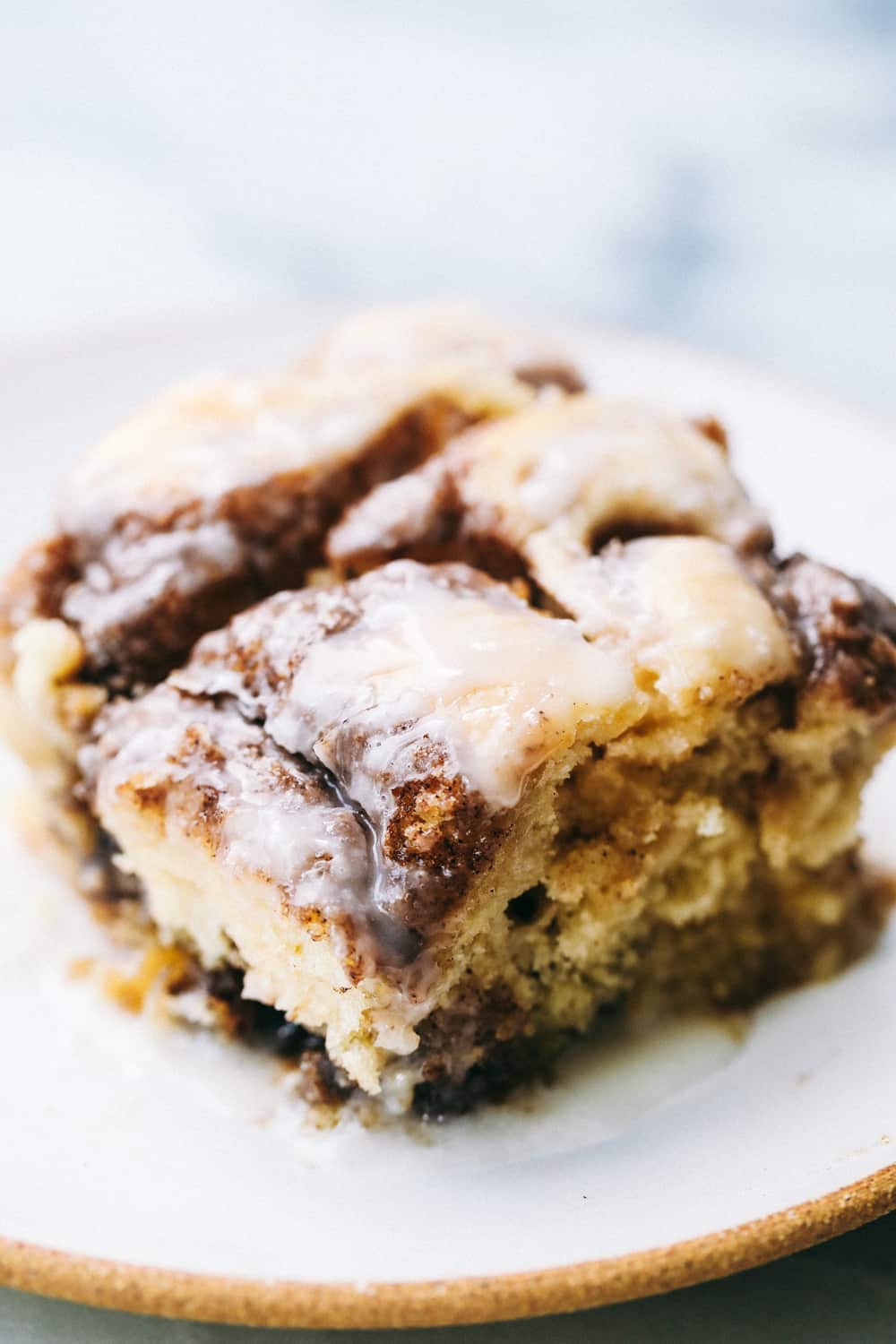 Cinnamon Roll Cakeย is a cinnamon roll turned into an ooey-gooey, delicious cake! Swirled with buttery brown sugar cinnamon and topped with a sweet glazeโฆ this is the BEST cake EVER! Closeup of a slice of cinnamon roll cake.