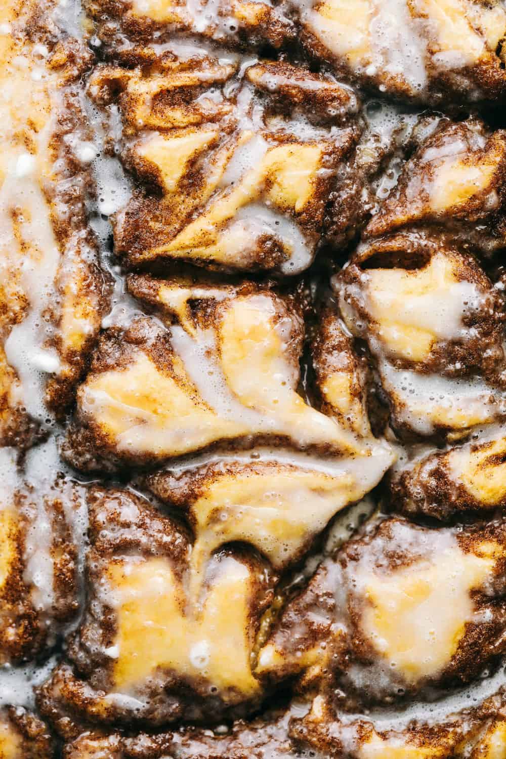 Cinnamon Roll Cakeย is a cinnamon roll turned into an ooey-gooey, delicious cake! Swirled with buttery brown sugar cinnamon and topped with a sweet glazeโฆ this is the BEST cake EVER! Closeup of cinnamon roll cake.
