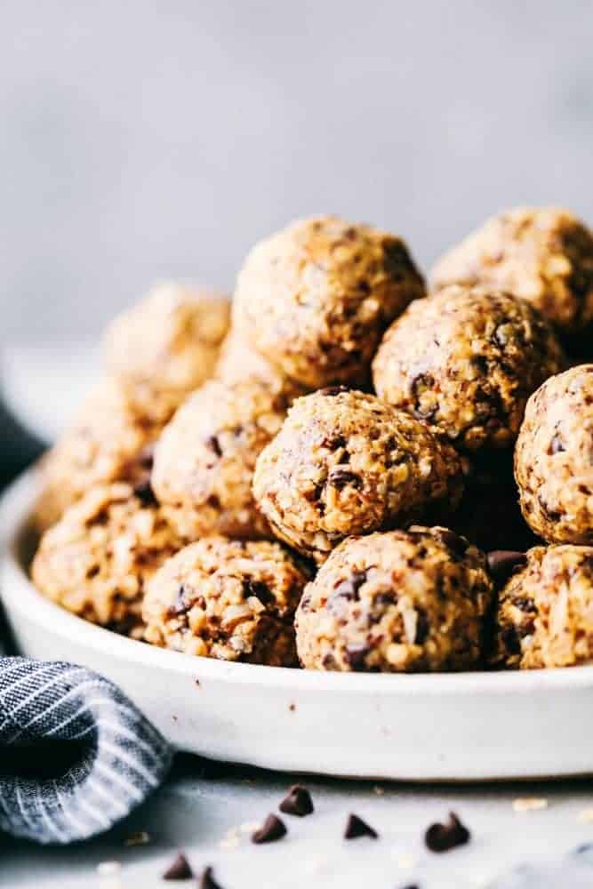 No Bake Energy Bites are packed with protein and make the perfect healthy snack or breakfast on the go! Loaded with oats, flax seed, peanut butter, coconut and chocolate chips, these little bites are amazing! No bake energy bites stacked in a bowl.