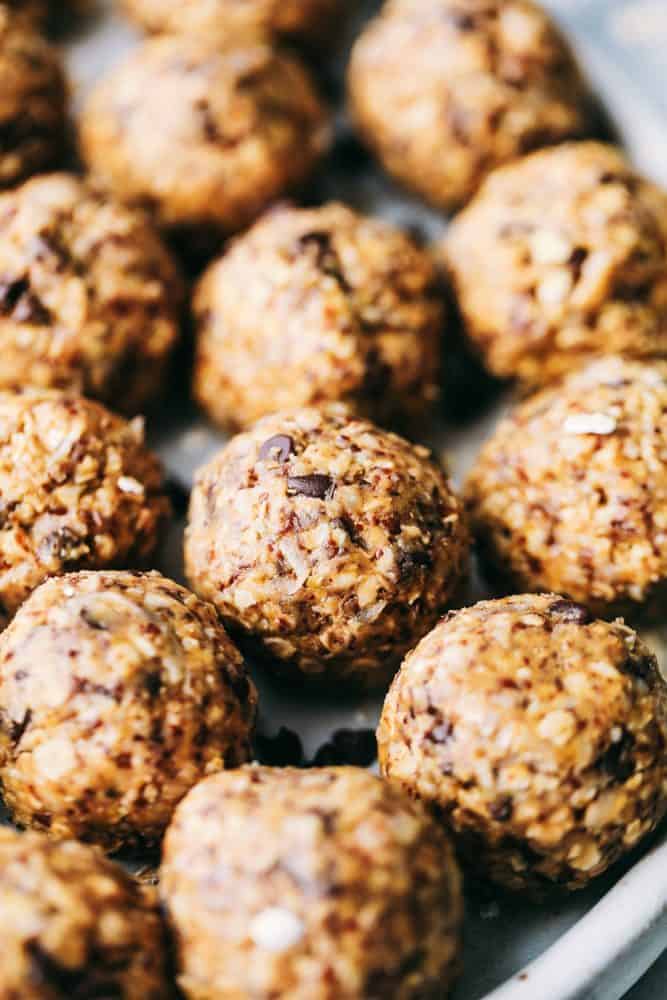 No Bake Energy Bites are packed with protein and make the perfect healthy snack or breakfast on the go! Loaded with oats, flax seed, peanut butter, coconut and chocolate chips, these little bites are amazing! Close up on rows of No Bake Energy Bites.