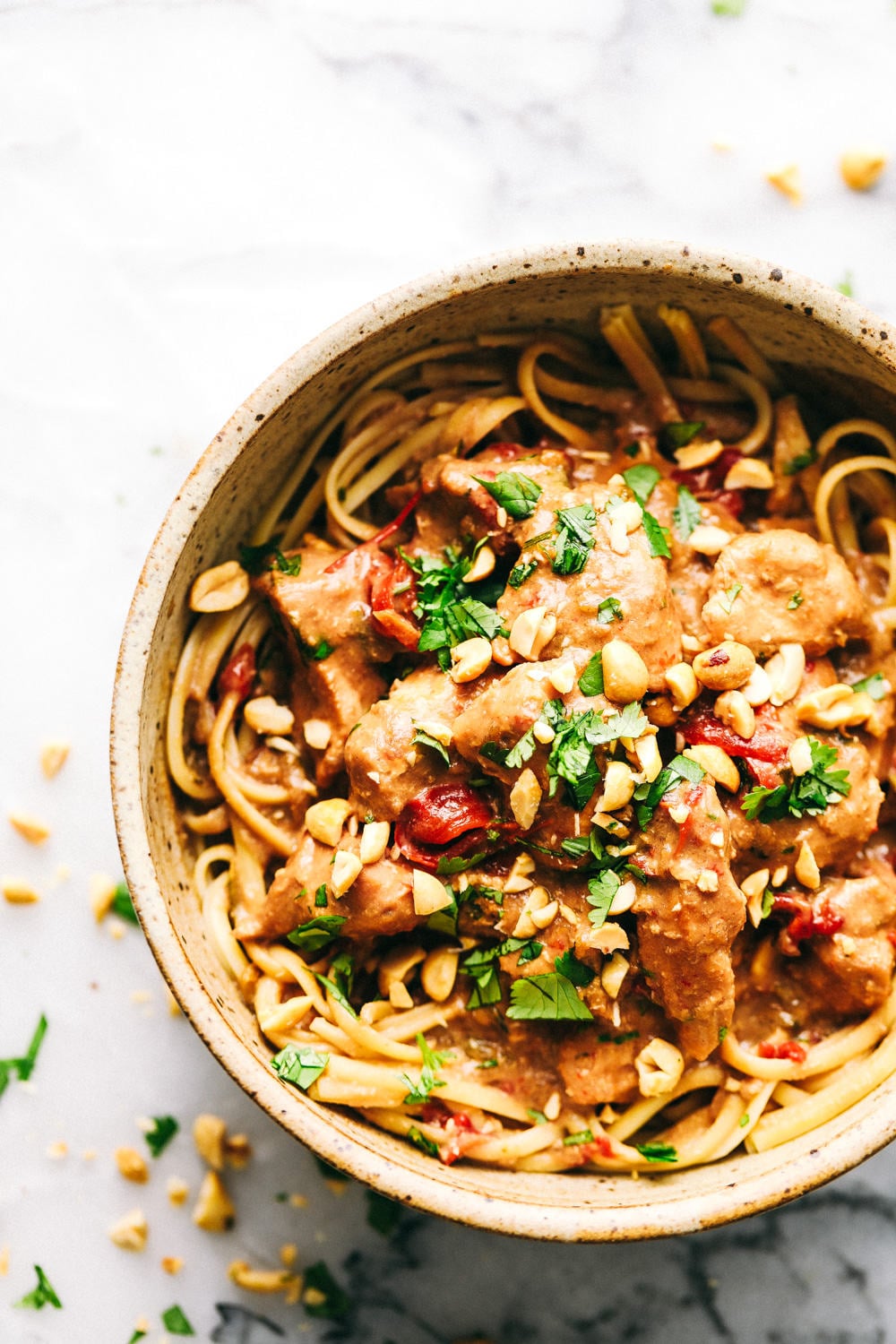 Slow Cooker Thai Peanut Chicken is a creamy, peanut flavor infused chicken that is served over thick, rich noodles. Easy to make in just a couple steps adding all the ingredients together letting the slow cooker do the work for you! Enjoy the smells that will fill your home while cooking during the day. Slow Cooker Thai Peanut Chicken in a bowl.