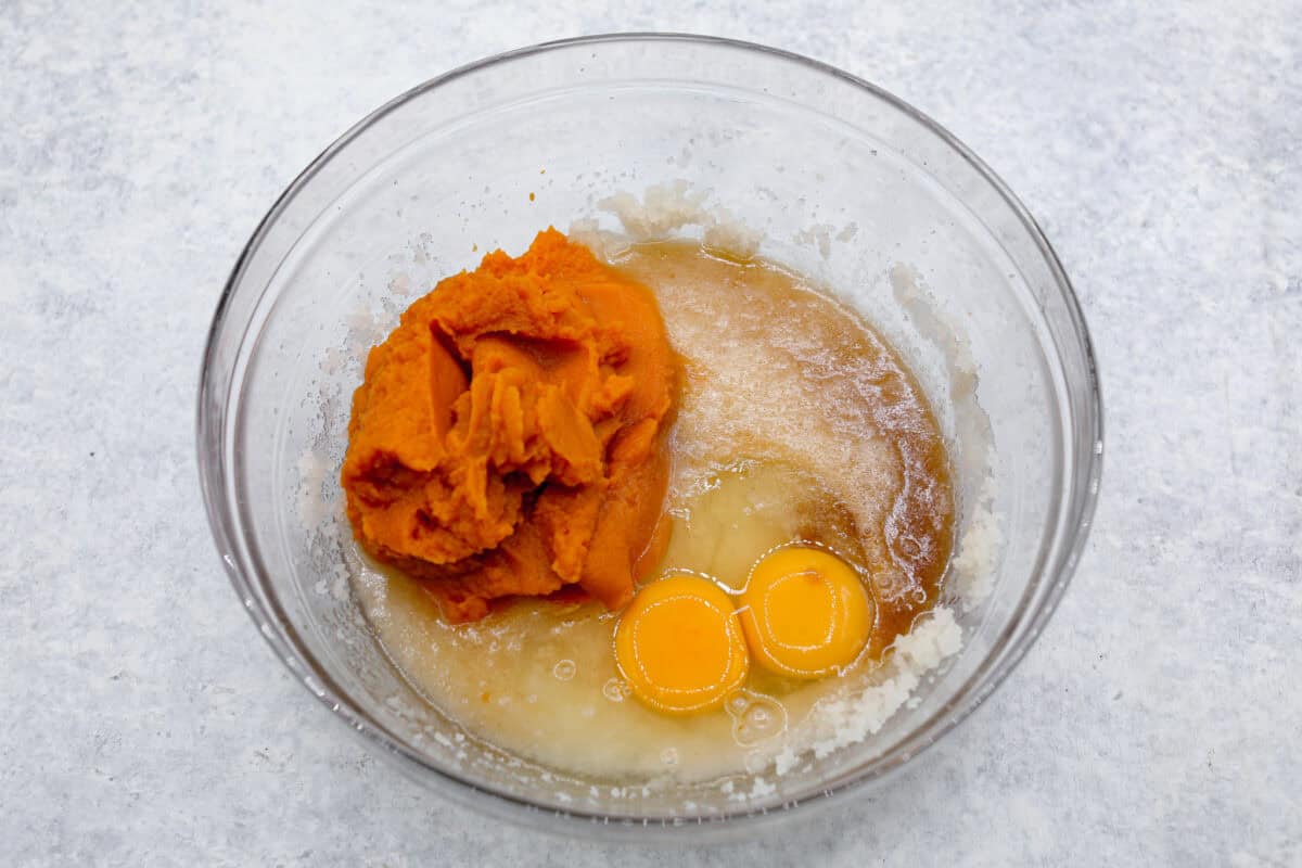 Pumpkin roll bars have all the things you love about pumpkin rolls without all of the hassle! They have perfectly spiced pumpkin cake with a smooth cream cheese swirl that will be sure to make this your new favorite fall dessert! Overhead shot of wet ingredients in a glass bowl.