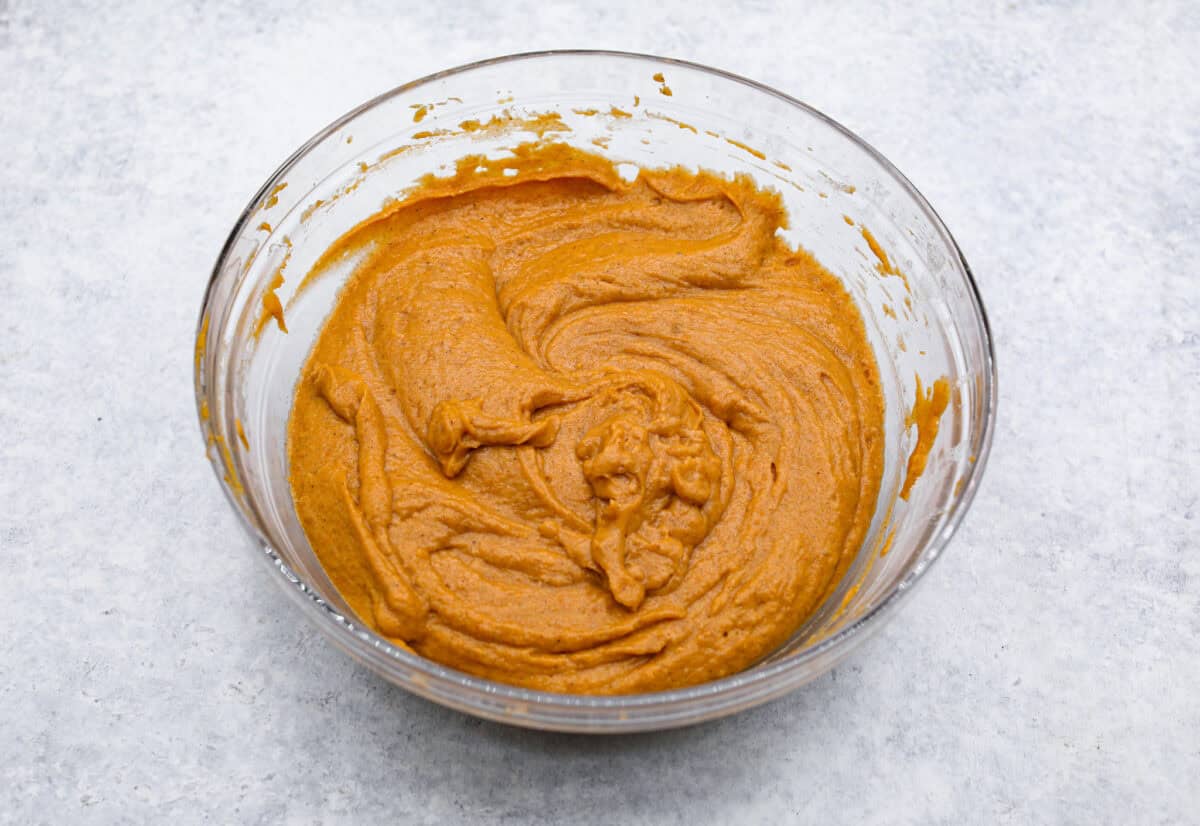Pumpkin roll bars have all the things you love about pumpkin rolls without all of the hassle! They have perfectly spiced pumpkin cake with a smooth cream cheese swirl that will be sure to make this your new favorite fall dessert! Overhead shot of wet and dry ingredients mixed together in a bowl.