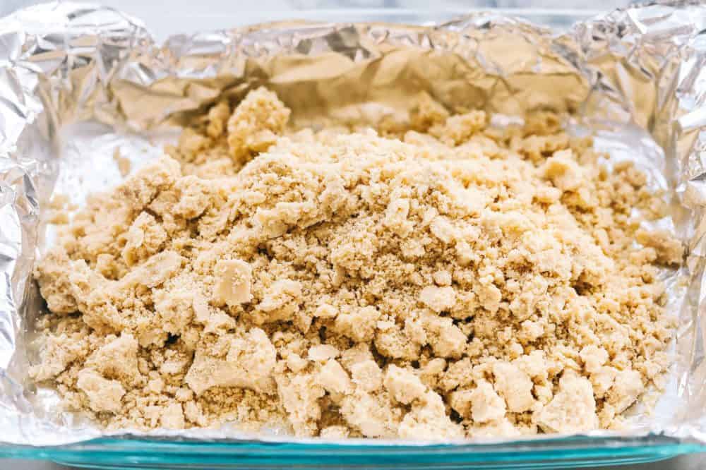 Best Ever Pecan Pie Bars takes the amazing pecan pie and transforms it into irresistible bars. A buttery shortbread crust that gets topped with a caramel pecan glaze, these are perfect for feeding a crowd! Bar base placed on aluminum foil.