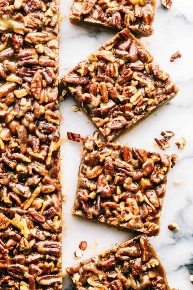 Best Ever Pecan Pie Bars takes the amazing pecan pie and transforms it into irresistible bars. A buttery shortbread crust that gets topped with a caramel pecan glaze, these are perfect for feeding a crowd! Cut Pecan Pie Bars.