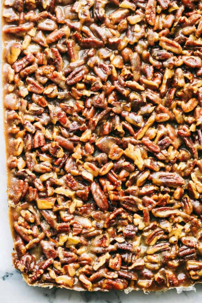 Best Ever Pecan Pie Bars takes the amazing pecan pie and transforms it into irresistible bars. A buttery shortbread crust that gets topped with a caramel pecan glaze, these are perfect for feeding a crowd! Overhead view of Pecan Pie Bars.