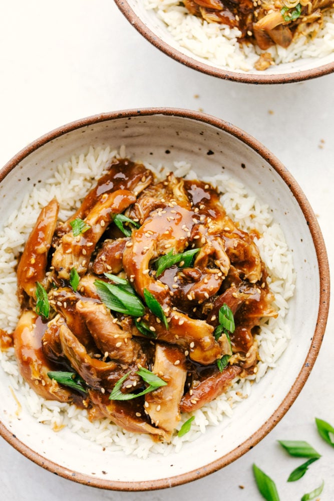 Slow Cooker Teriyaki Chicken is a simple saucy, sweet and tangy chicken served over tender long grain rice that truly satisfies. The aroma that will fill your kitchen will make your mouth water all day, the hardest part of this will be waiting till it's done. It's so simple and so flavorful, it'll become a standard in your recipe rotation. Slow Cooker Teriyaki Chicken on top of rice.