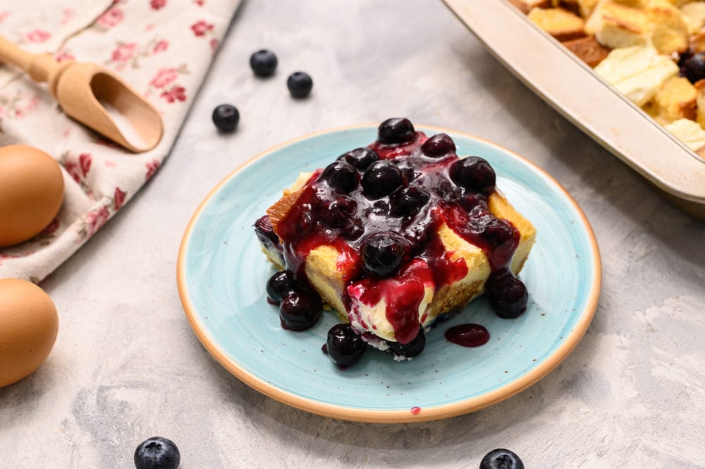 Warm, fruity, soft bites of breakfast perfection is what you get when you make this overnight blueberry french toast! I love going to bed knowing that when I wake up I will have breakfast ready to pop in the oven and enjoy! What a great way to start the day! Overnight blueberry breakfast with blueberries overtop.