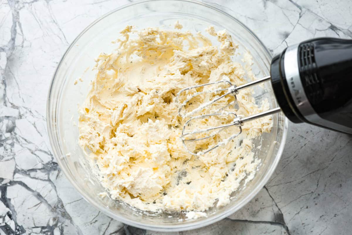 This bacon ranch cheese ball will be your favorite go-to appetizer! The winning combination of bacon, ranch seasoning, and cheddar cheese really stands out in this tasty cheese ball. Serve with crackers and watch everyone devour it! First photo of the cream cheese and ranch seasoning mixed in a bowl.