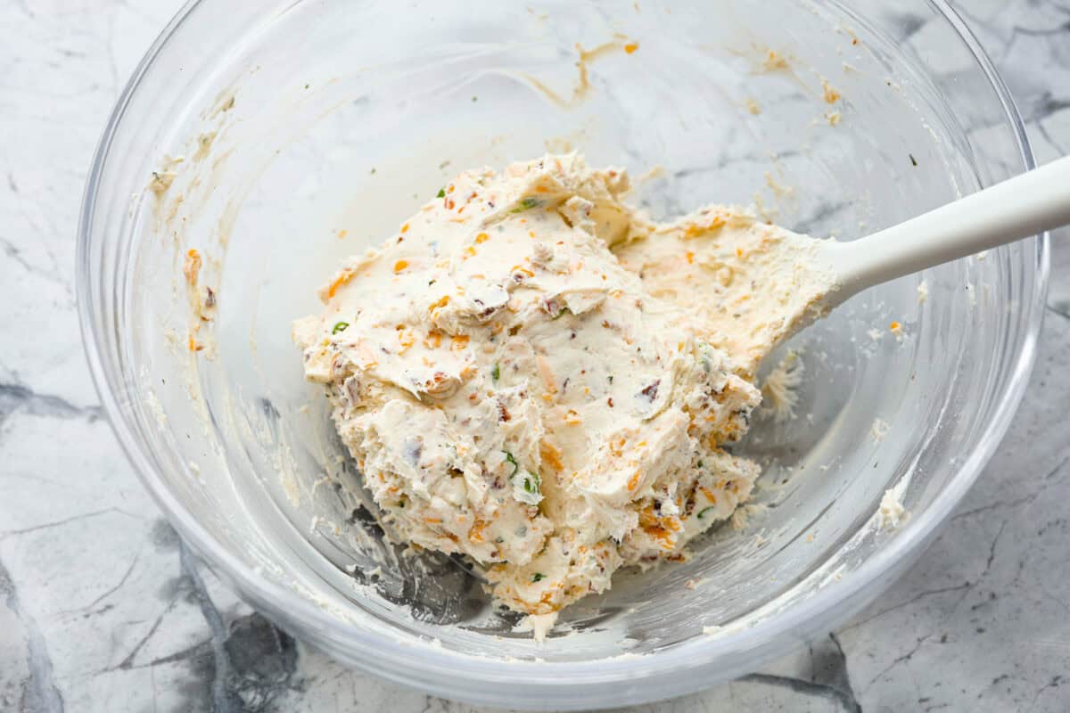 This bacon ranch cheese ball will be your favorite go-to appetizer! The winning combination of bacon, ranch seasoning, and cheddar cheese really stands out in this tasty cheese ball. Serve with crackers and watch everyone devour it! Third photo of the cream cheese mixture combined.