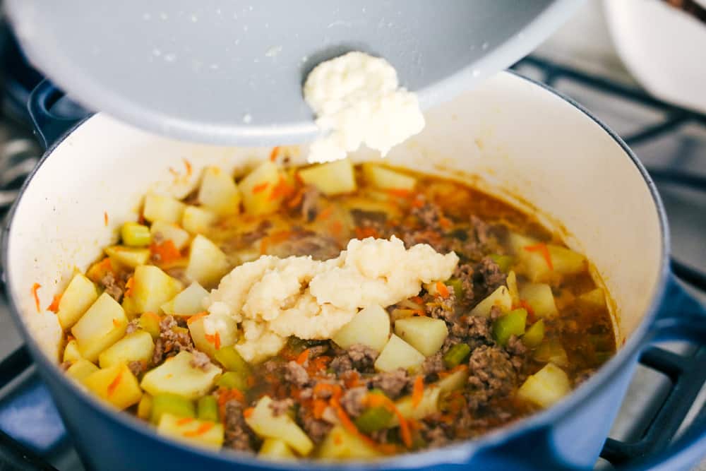 Award Winning Cheeseburger Soup is a thick and hearty soup with lean, tender ground beef, shredded carrots,ย dicedย celery and potatoes in a warm and creamy cheese soup. This is an award winning soup and it is excellent!ย Adding in the roux to the soup.
