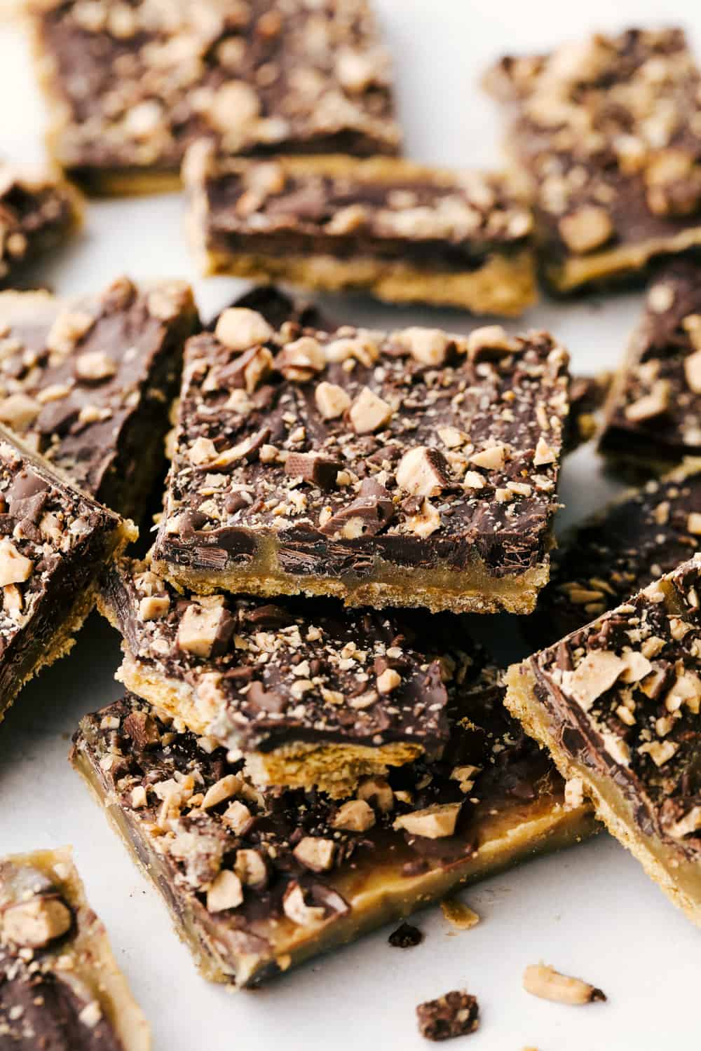 This super easy Graham Cracker Toffee is so delicious and addictive. Perfect for cookie plates to give to neighbors, bring to parties or just to eat! It's quick and luscious. We love to make this graham cracker toffee every year! Luscious Graham Cracker Toffee staked on a plate.