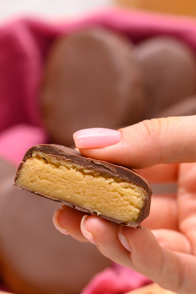 These homemade Reese's eggs are to die for!! With a creamy peanut butter center inside a thick, rich chocolate covering, these make the best Easter treat! A homemade Reese's egg cut in half to see the peanut butter inside and chocolate outside.