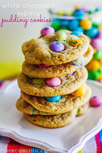 I made a batch of these in about 10 minutes. They are quick and easy and absolutely amazing! Love all of the fun bright colors for spring. Being that I now have 6 bags of these, I will definitely be making them again! White chocolate M&Ms Pudding Cookies stacked on white plate