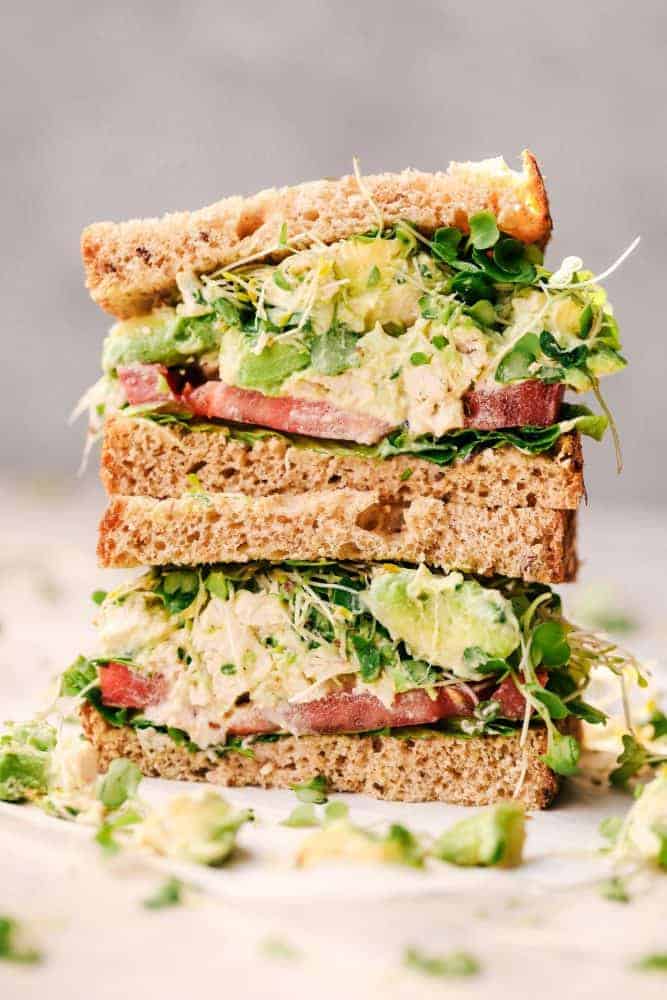 Avocado Chicken Salad is easy to make and you will never want to make your chicken salad without avocado again! Perfect on a sandwich, croissant or served with tortilla chips! Avocado Chicken Salad sandwich cut in half and stacked.