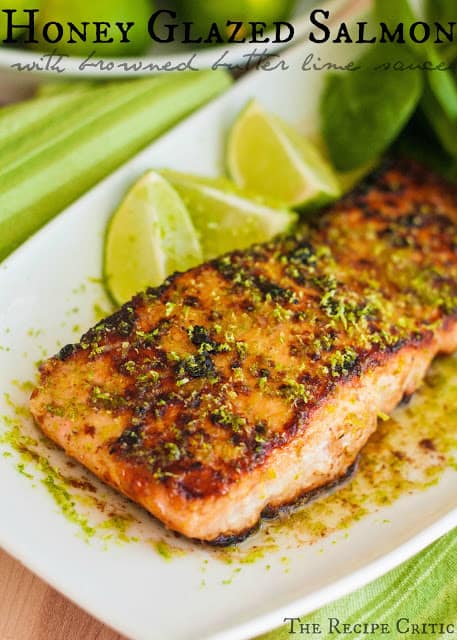 This was the BEST salmon I think that I have had. It tasted like I was at a 5 star restaurant eating this. And I love that it was pan seared and had a crust to it and it was so tender and melted in my mouth! Honey glazed salmon with browned butter lime sauce on a white plate with 3 lime slices.