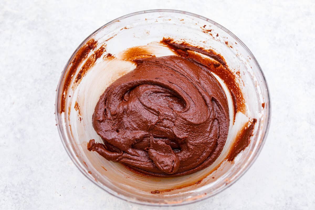 The best of both worlds collide in these peanut butter brownies! Fudgy homemade brownies are swirled with a sweet peanut butter mixture. The combination is an explosion of rich decadent flavors! Third photo of the wet and dry ingredients combined to make the brownie batter.
