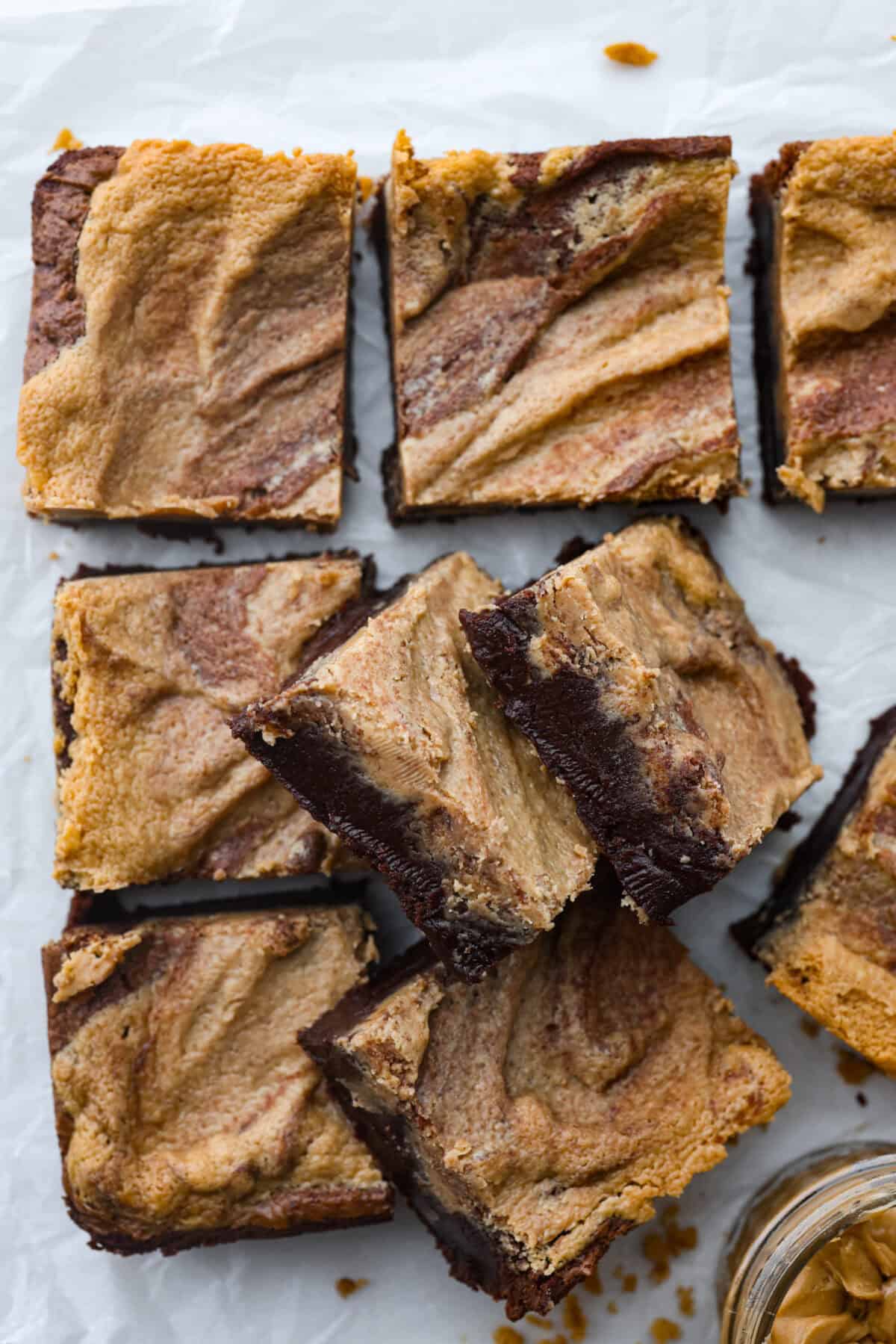 The best of both worlds collide in these peanut butter brownies! Fudgy homemade brownies are swirled with a sweet peanut butter mixture. The combination is an explosion of rich decadent flavors! Top view of peanut butter brownies cut into squares.