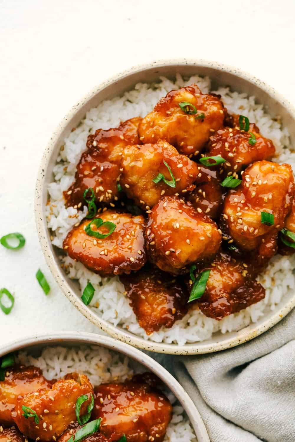 Baked Sweet and Sour Chicken is 1000x better than any takeout! It's crispy on the outside, juicy on the inside and exploding with flavor. There is a reason why this is our favorite recipe on the blog! Closeup of crispy, juicy, tender Baked Sweet and Sour Chicken.