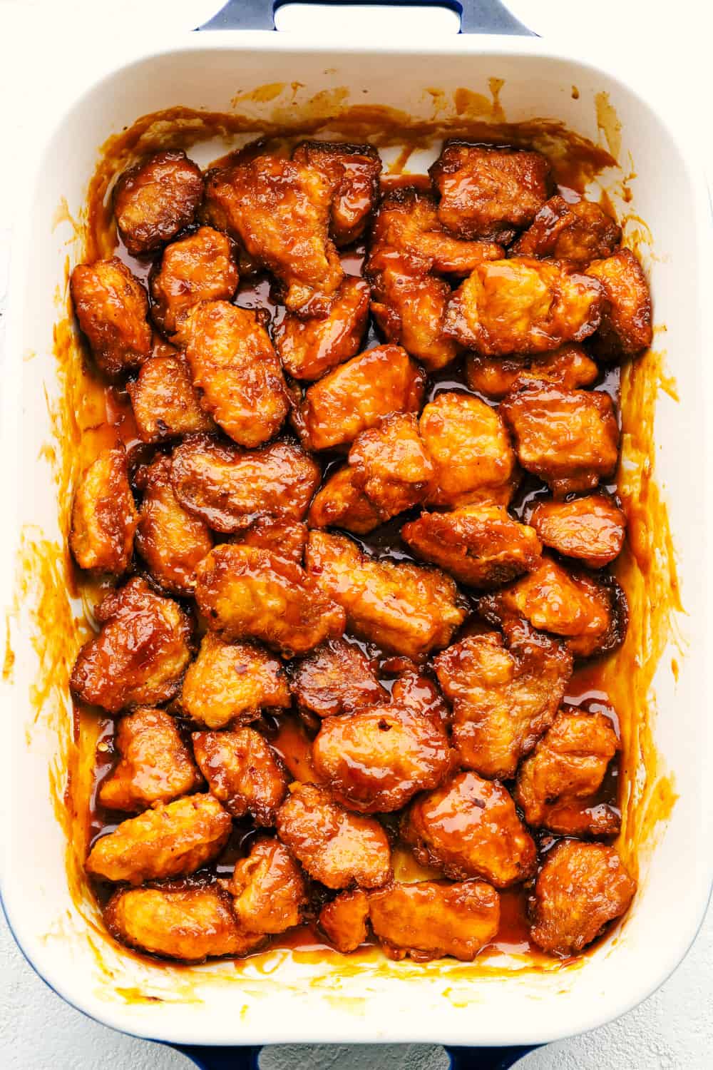 This Firecracker Chicken is sweet, spicy and adds a nice kick to your meal. The chicken is super tender and juicy and once you smother it in the flavorful sauce, you will have everyone wanting to come back for seconds! A pan of cooked chicken with the sauce.