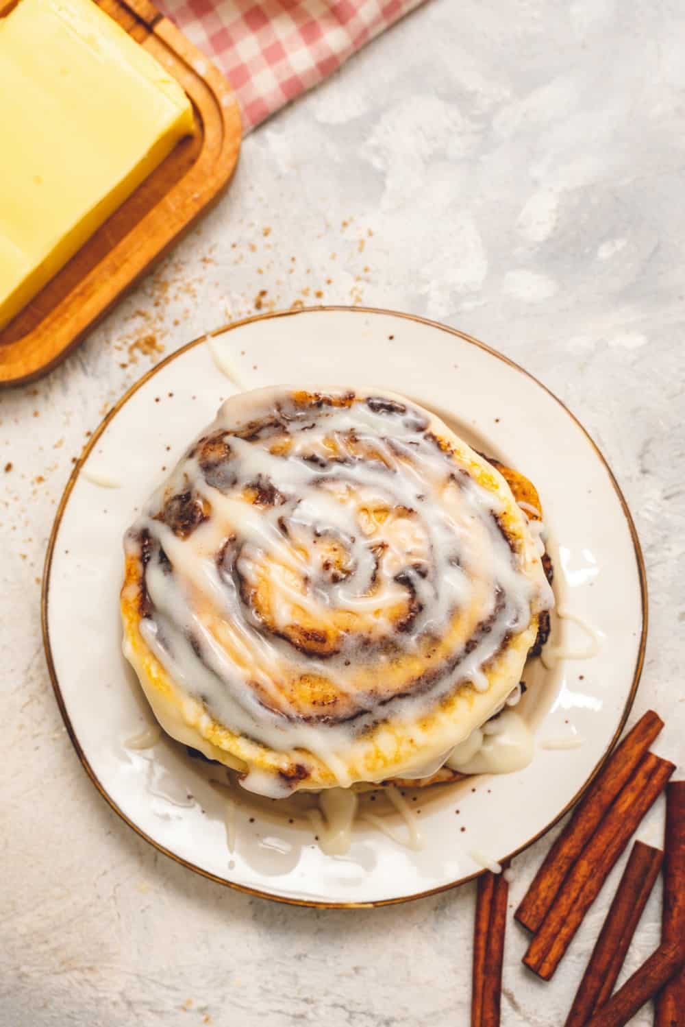 Cinnamon Roll Pancakes are aย delicious homemadeย pancake mix swirled with cinnamon roll filling and drizzled with aย delicious cream cheese glaze. These are pureย deliciousness!ย Cinnamon roll pancakes stacked on top of each other with cream cheese glaze drizzled over top.