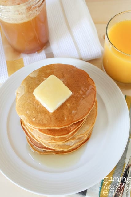 Delicious Pumpkin Pancakes made with healthier ingredients! Stack of pumpkin pancakes on a white plate.