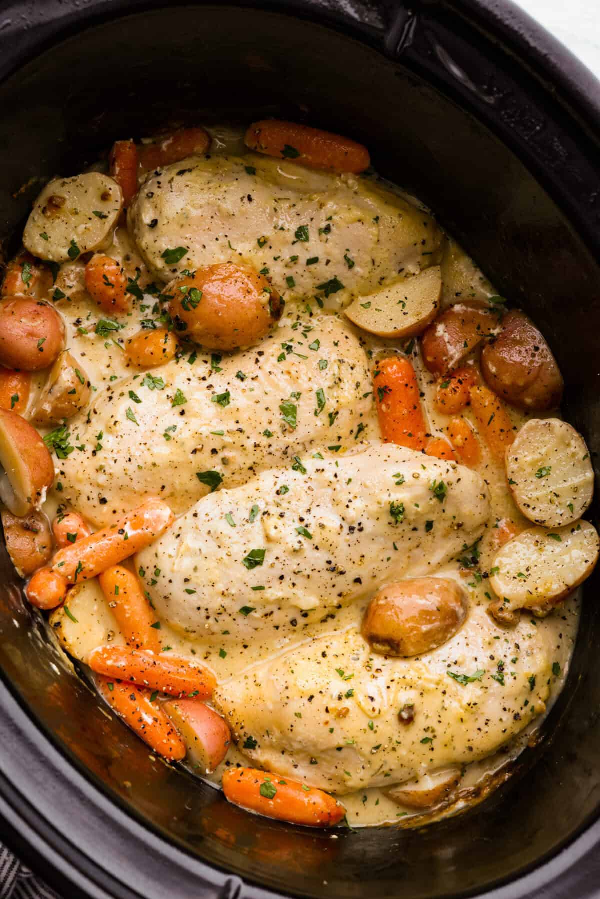 My Slow Cooker Creamy Ranch Chicken takes 10 minutes of prep and uses 6 simple ingredients. It's so good your whole family is going to love it, even your picky eaters! Top down shot of slow cooker creamy ranch chicken in a crock pot.