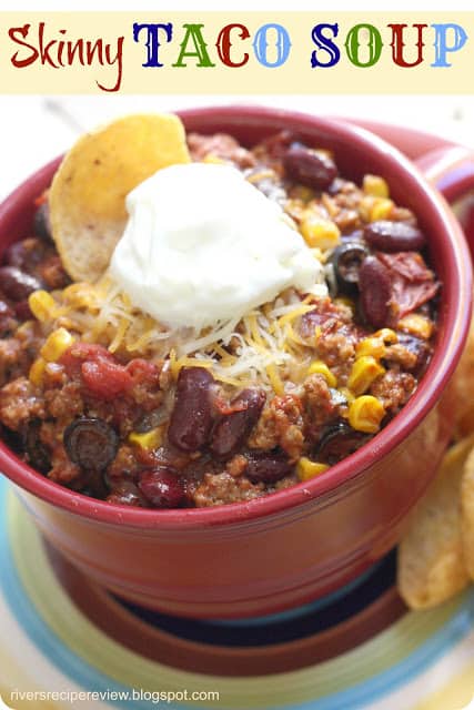 This soup is healthy and packed with nutrients, not to mention flavor! Skinny Taco soup in a red bowl with a dollop of sour cream and tortilla chip.
