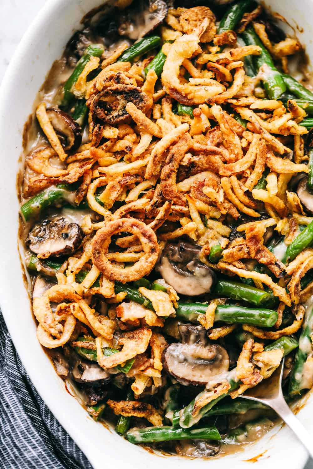 Green Bean Casseroleย is a classic, savory side dish that is favored by all! Filled with fresh mushrooms, garlic, parmesan and baked in a creamy sauce, thereย won't be a green bean leftย with this freshly made casserole.ย green bean casserole