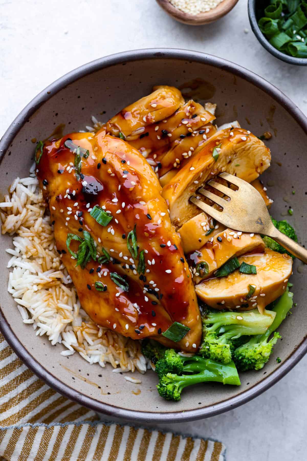 Baked teriyaki chicken is a healthy, delicious dish that comes together in just 45 minutes! The tender, moist chicken is drenched in a sweet and savory teriyaki glaze. Perfect served over some rice and a side of veggies, and the best partโฆ the entire family will love it! Overhead shot of plated baked teriyaki chicken.