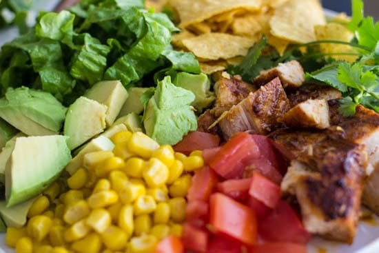A delicious taco salad using fresh ingredients and a delicious and easy dressing to go on top! Close up photo of the ingredients of chicken taco salad.