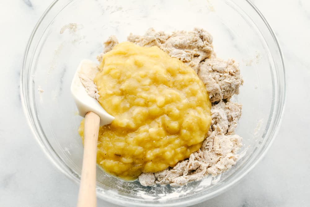 These banana pancakes are perfectly soft and fluffy and taste just like warm banana bread... in pancake form, of course! It's a great recipe to use when you have any over-ripe bananas! Banana mix in with ingredients in a glass bowl and spatula