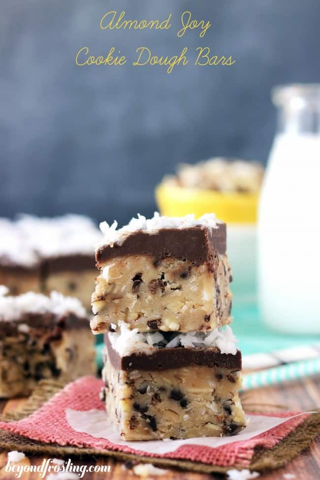 Amazing NO BAKE almond joy cookie dough bars that are packed with delicious flavors! Almond joy cookie cough bars stacked on top of one another.