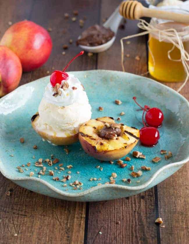 By grilling fruit, it brings out a lot of the natural sugars and sweetness in the fruit. Plus, the fruit part is still healthy. Totally a win โ win. Grilled Nectarine Sundae on a blue plate on a wooden table.