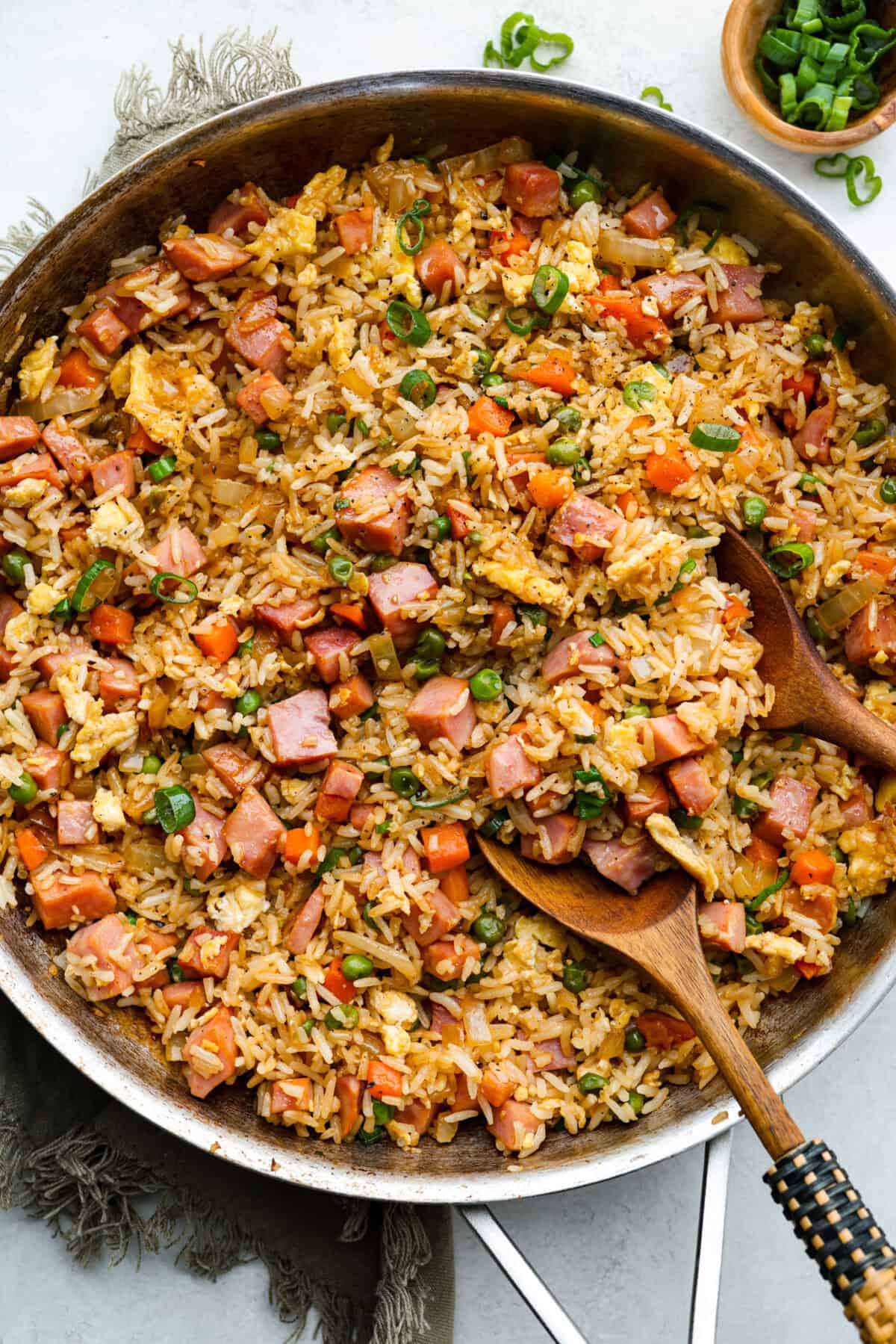 I know how much you guys love my fried rice recipes, and this Ham Fried Rice is a classic! Just toss in leftover rice, ham, and a few simple ingredients, itโs ready in under 30 minutes! Overhead shot of ham fried rice in a skillet.