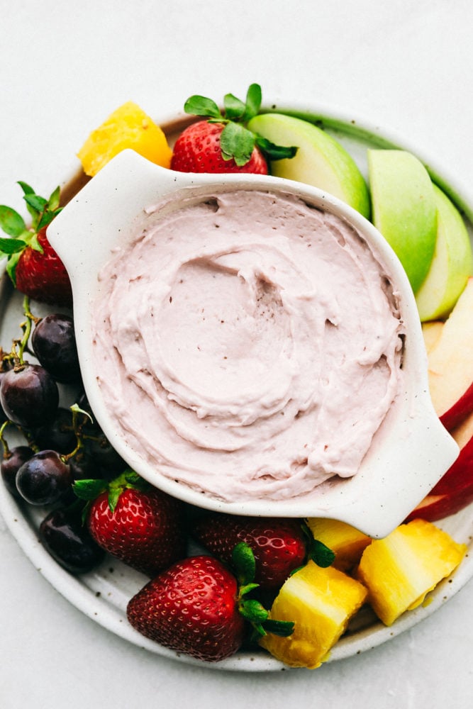 The best fruit dip that requires little effort and is absolutely fantastic! And it is only 2 ingredients! Strawberry Cream Cheese Fruit Dip in a white dish with fresh fruit and berries on the side to dip.