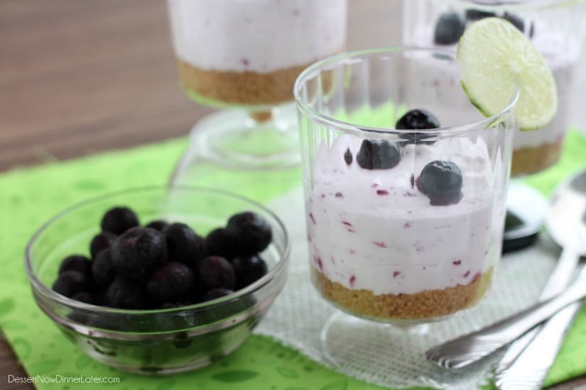 A delicious No Bake Blueberry Lime Cheesecake dessert that the family is sure to love! Blueberry Lime No-Bake Cheesecake Cup with a cup of fresh blueberries on the side.