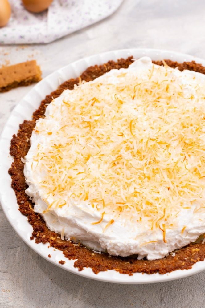 Coconut Cream Key Lime Pie is a fresh, easy to make dessert with a smooth creamy filling and a buttery crunch in the crust. It is beautiful and makes a great sweet treat when entertaining because everyone LOVES it!! Close up on key lime pie.